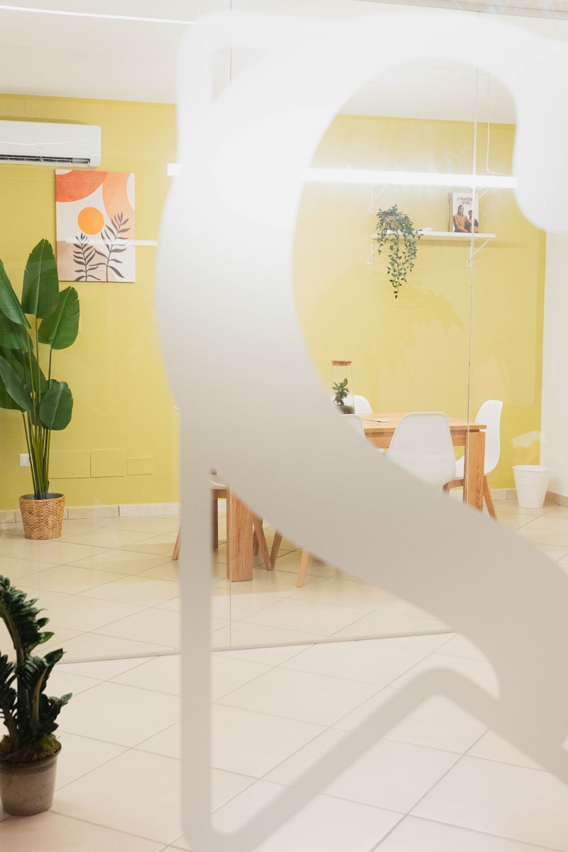 La sala vista attraverso la vetrata con il logo Nous